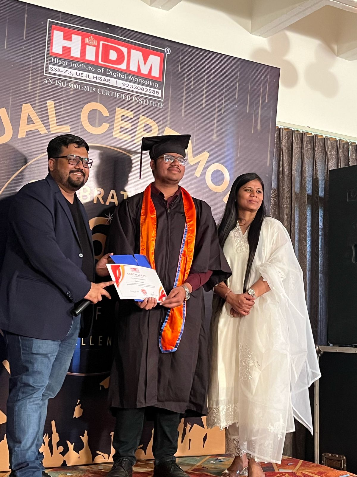 HIDM student smiling with certificate in hand.