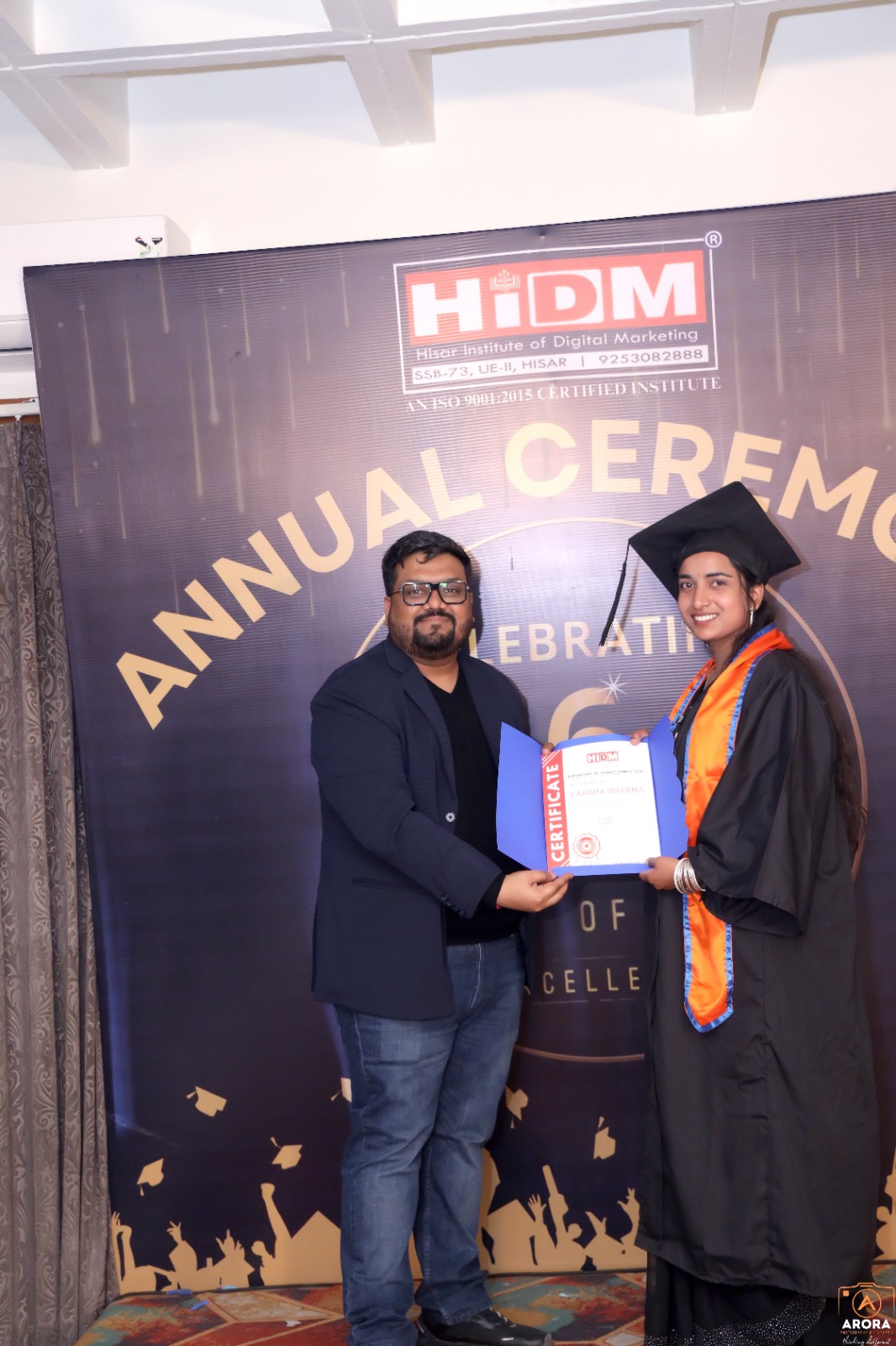 Joyful student holding certificate at HIDM celebration.
