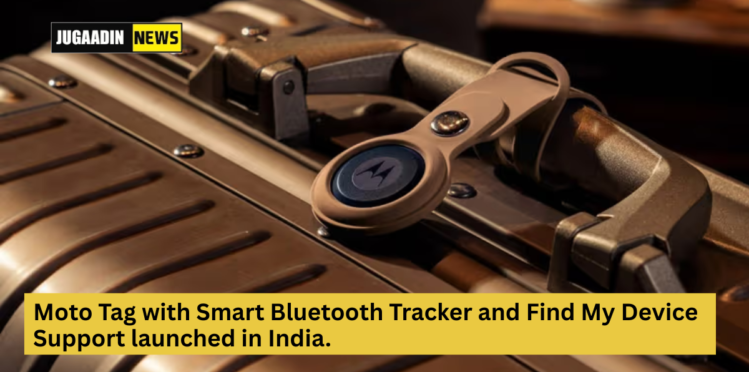 A Moto Tag smart Bluetooth tracker is attached to the handle of a metallic suitcase. The device features the Motorola logo in the center and is secured with a beige strap. The image announces the launch of the Moto Tag with Find My Device support in India, with the Jugaadin News logo at the top left and a yellow text banner at the bottom.