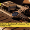 A Moto Tag smart Bluetooth tracker is attached to the handle of a metallic suitcase. The device features the Motorola logo in the center and is secured with a beige strap. The image announces the launch of the Moto Tag with Find My Device support in India, with the Jugaadin News logo at the top left and a yellow text banner at the bottom.