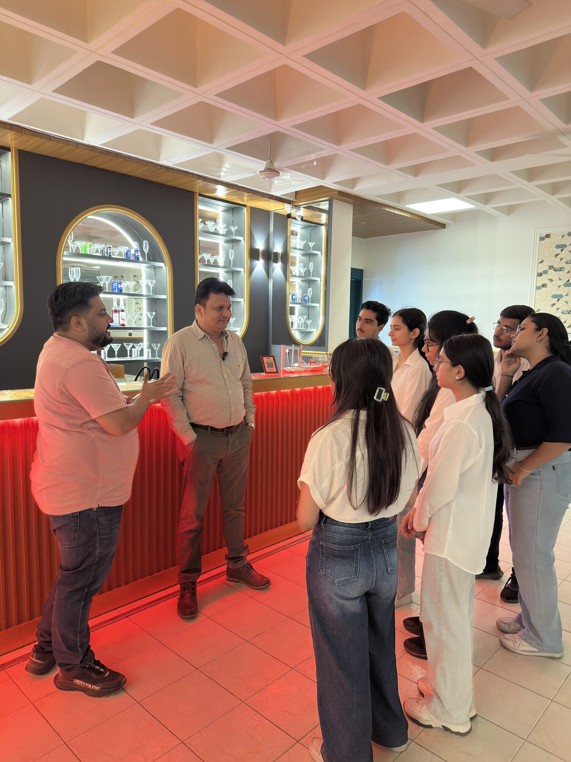 A group of HIDM female students listening to a briefing by a team member at Vibes Restaurant’s indoor dining area