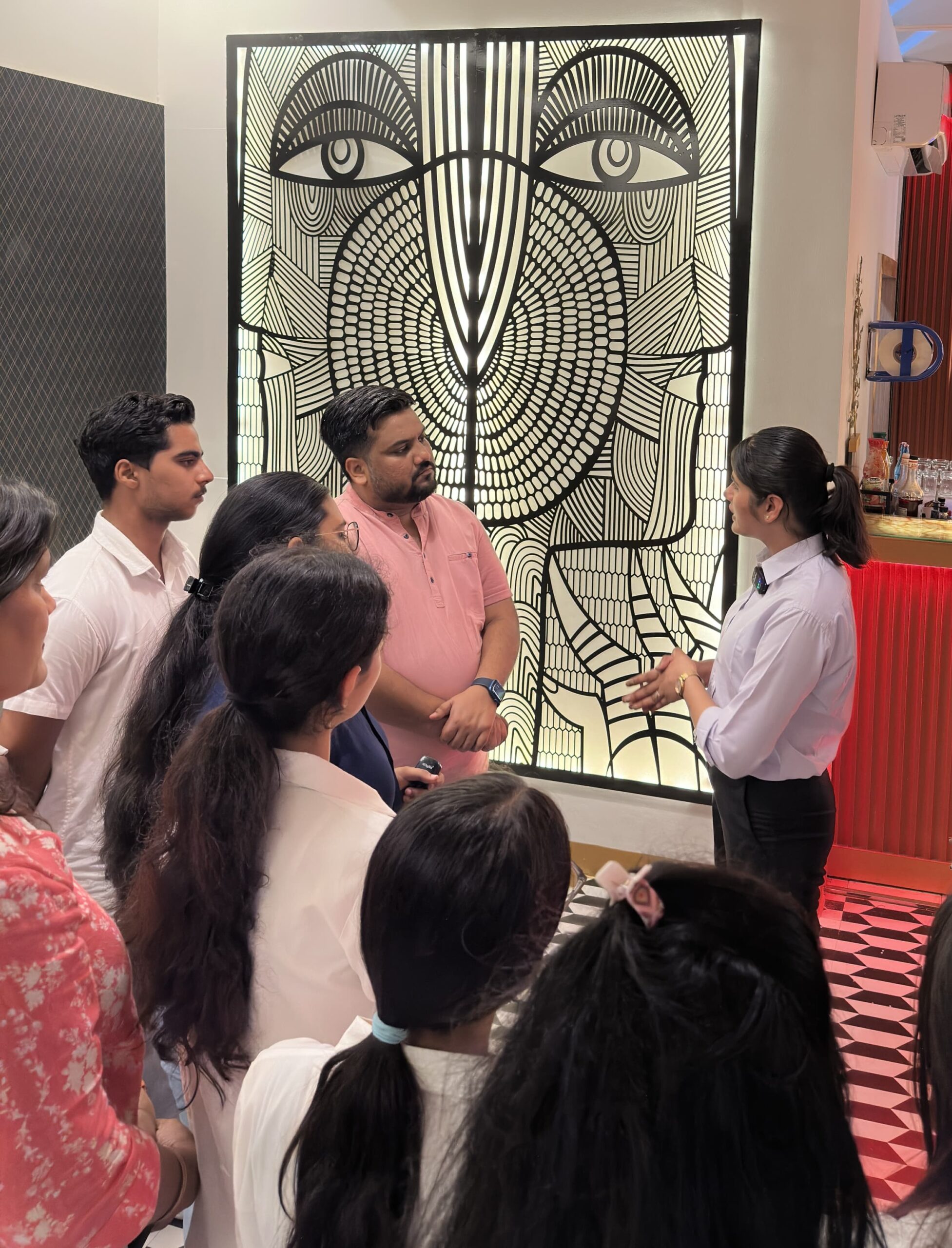 HIDM students listening to a staff member explaining restaurant branding strategies at Vibes Restaurant, Gymkhana Club Hisar.