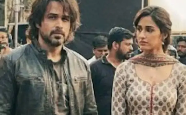 Emraan hashmi and Disha Patani standing together at a public event, with other people in the background